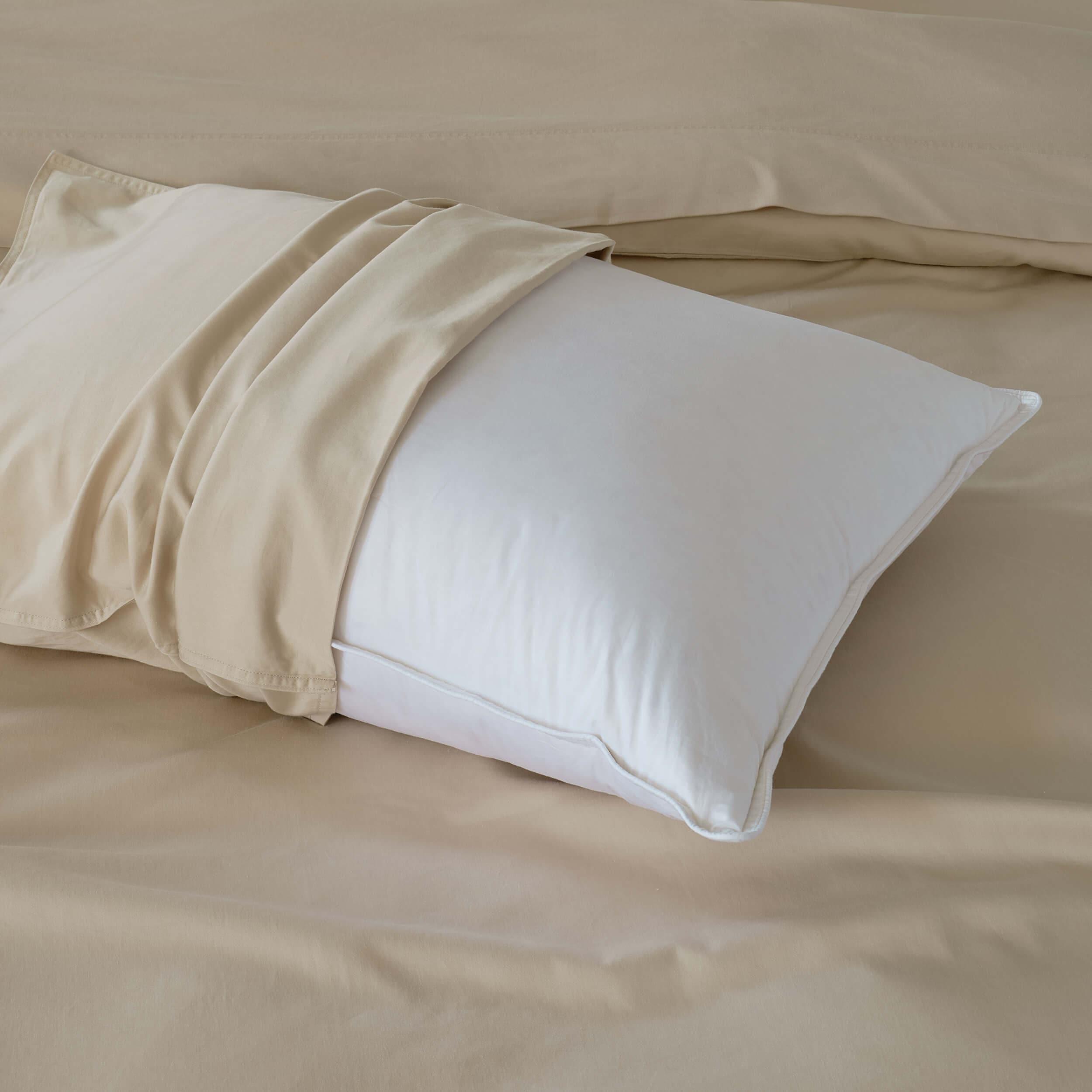 The white down pillow offers a cloud-like softness and support for a restful night's sleep.